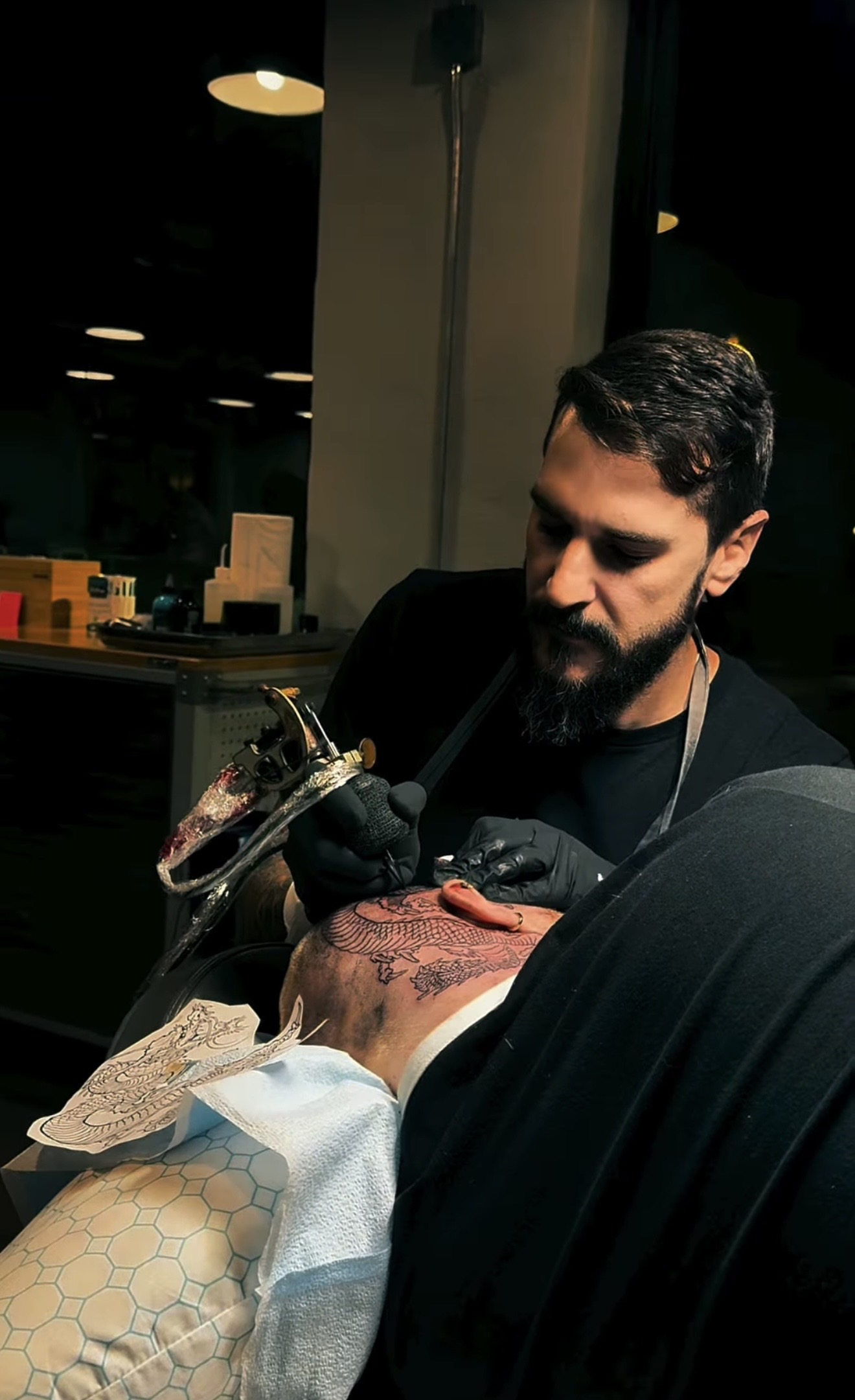 Tattoo artist Flávio working on a Japanese tattoo