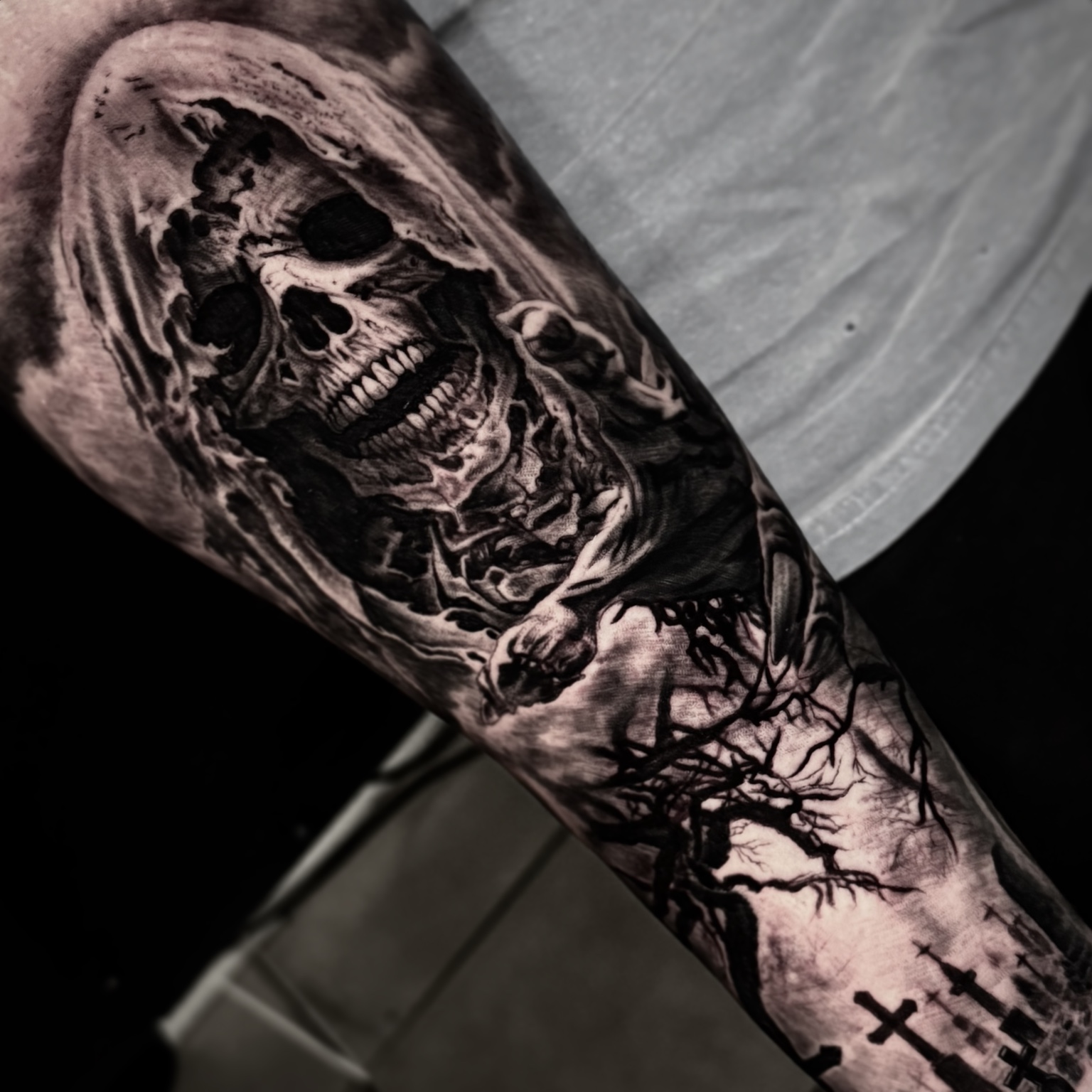 Black and grey skull and cemetery tattoo by Maverick Mayes