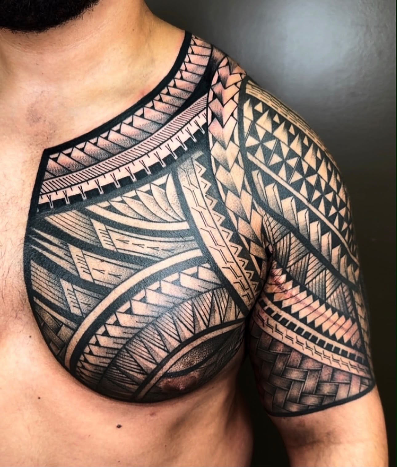 Polynesian chest and shoulder tattoo by Tchelo